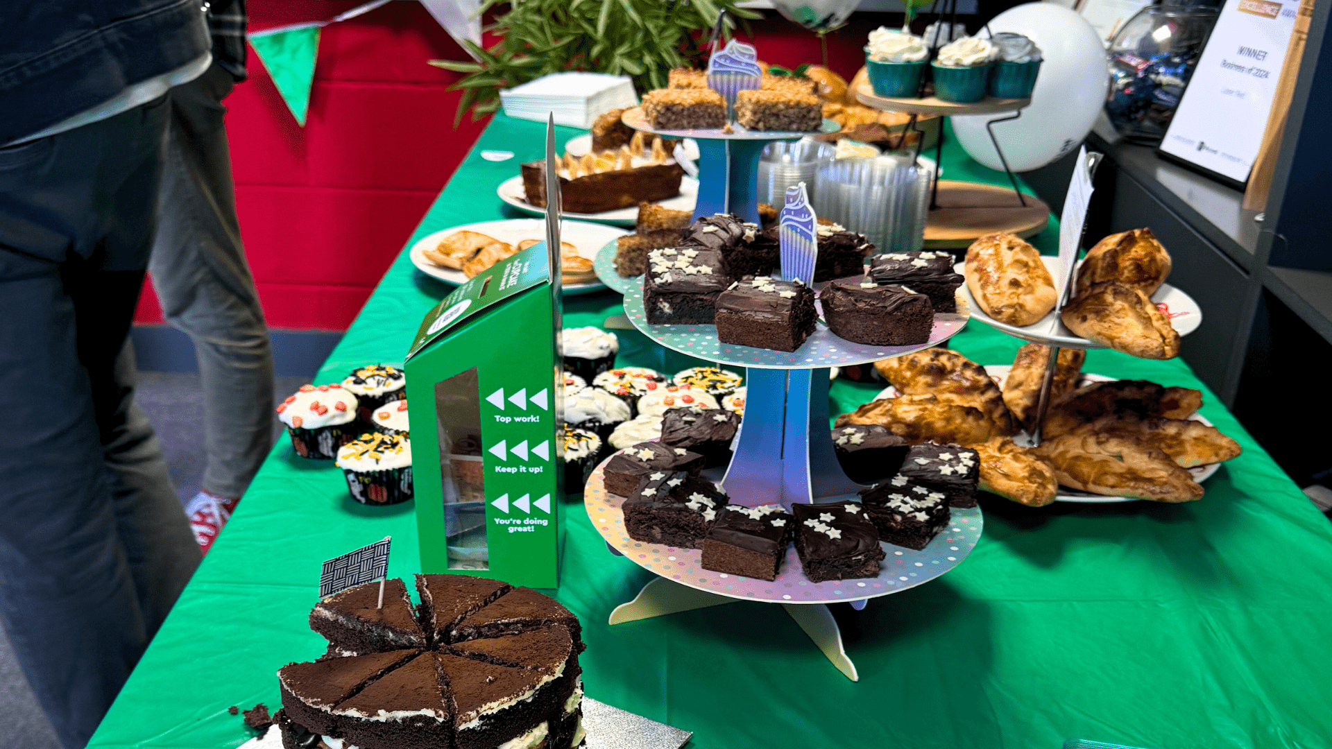 cakes, brownies, pastries and more on a table with a donations box