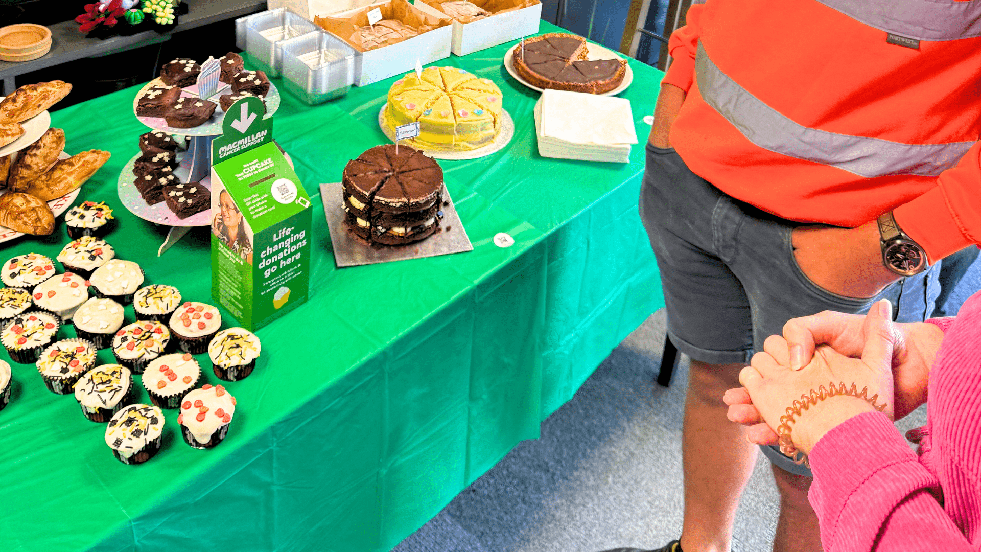 people stood in front of the cakes table